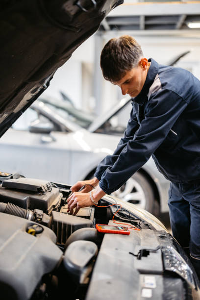 istock Young Car Mechanic Checking Voltage On A Car Battery In His Garage 2161470298