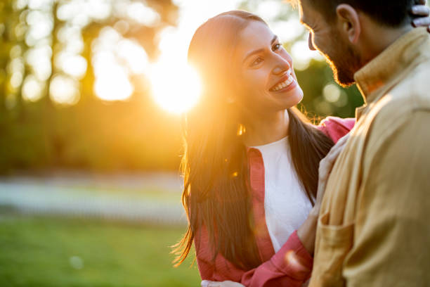 istock Pair lovingly gazing at each other in warm sunlight. 2161478306