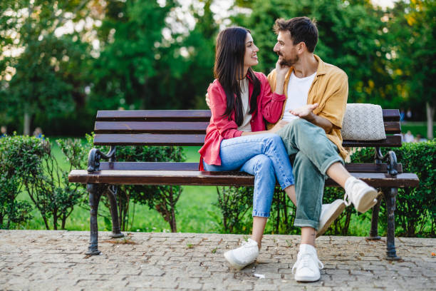 istock Couple chatting happily on a park bench 2161478384