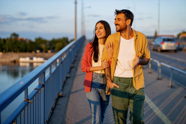 istock Happy couple walking on a bridge during sunset. 2161478468