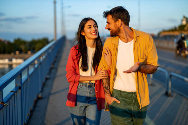 istock Couple walking closely on a bridge, smiling joyfully. 2161478483