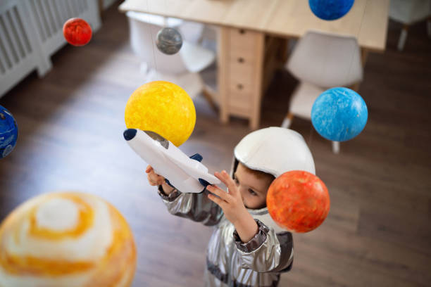 istock Boy in a space suit playing at home, imagining space travel. 2161478990
