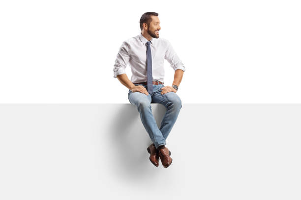 Businessman sitting on a panel and looking to the side isolated on white background
