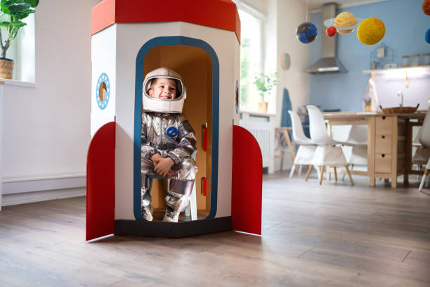 istock Boy in a space suit playing at home, imagining space travel. 2161480639