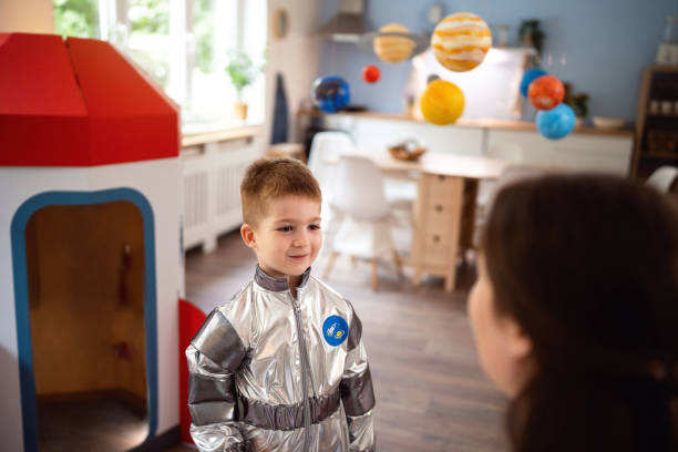 istock Boy in a space suit playing with his mom at home, imagining space travel. 2161481119