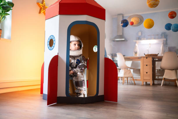 istock Boy in a space suit playing at home, imagining space travel. 2161481428