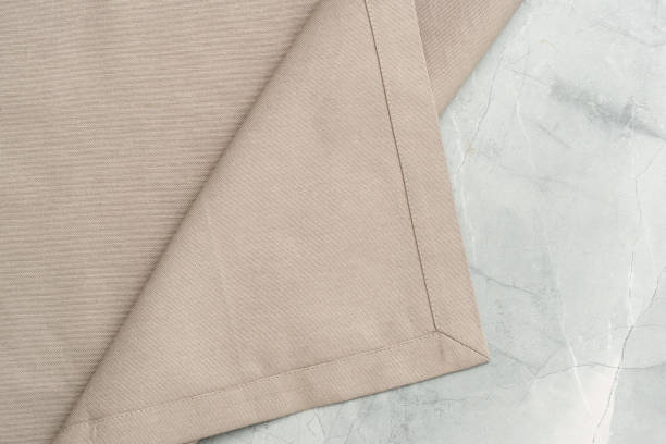 istock Close Up of a Beige Fabric Napkin Folded on a Marble Surface 2161481586
