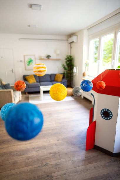 istock Cardboard rocket ship and wall hanging solar system at the modern apartment 2161481751