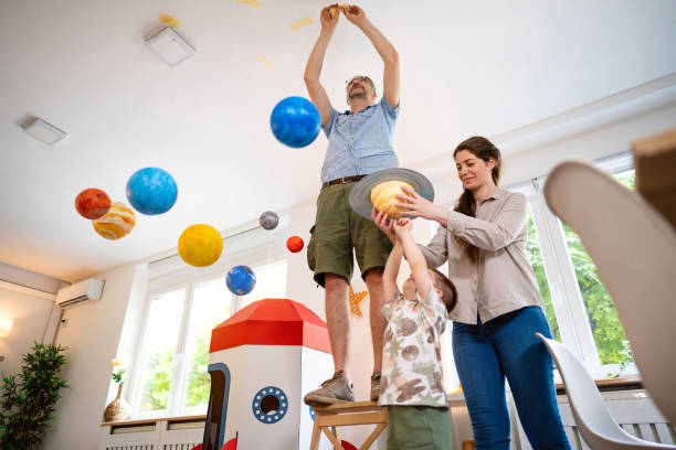 istock Family decorating their home with a model of a solar system 2161481784