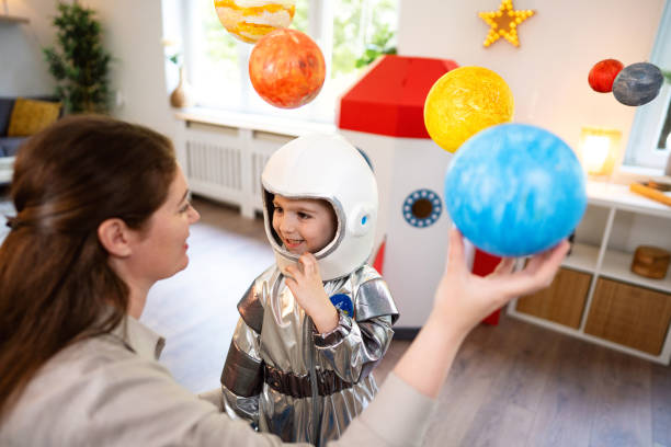 istock Boy in a space suit playing with his mom at home, imagining space travel. 2161482046