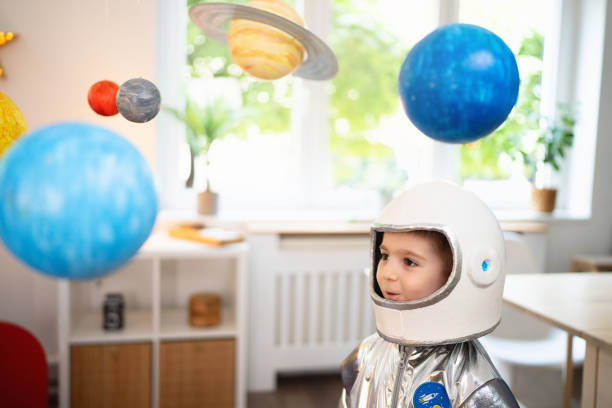istock Boy in a space suit playing at home, imagining space travel. 2161482648