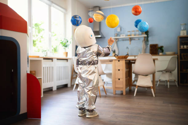 istock Boy in a space suit playing at home, imagining space travel. 2161482672