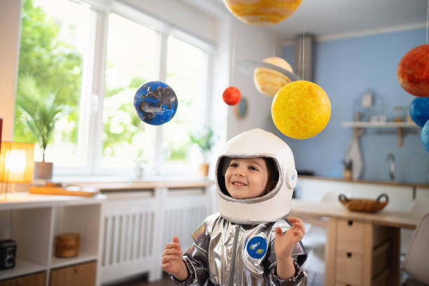 istock Boy in a space suit playing at home, imagining space travel. 2161482678