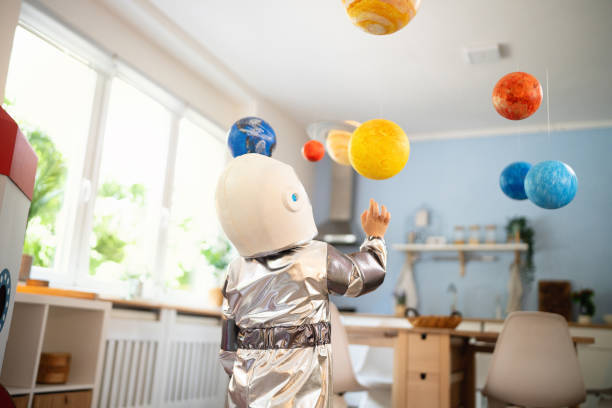 istock Boy in a space suit playing at home, imagining space travel. 2161482680