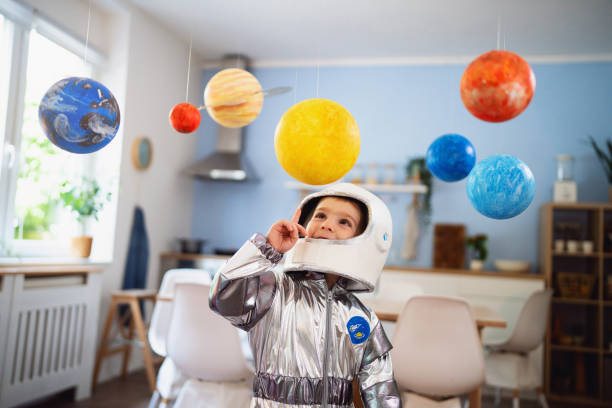 istock Boy in a space suit playing at home, imagining space travel. 2161483134