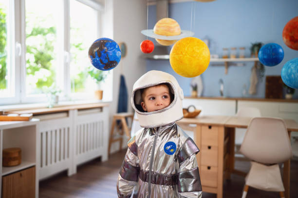 istock Boy in a space suit playing at home, imagining space travel. 2161483135