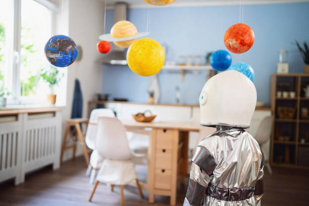 istock Boy in a space suit playing at home, imagining space travel. 2161483136