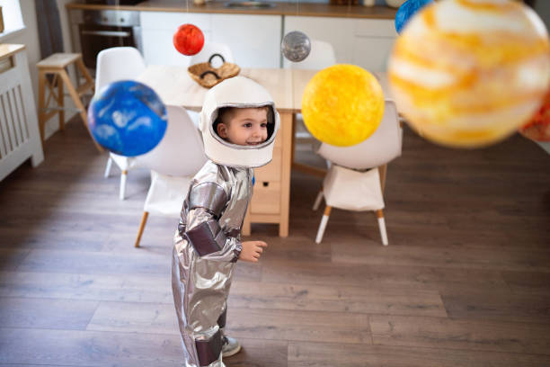 istock Boy in a space suit playing at home, imagining space travel. 2161483652