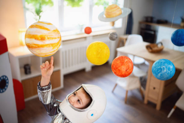 istock Boy in a space suit playing at home, imagining space travel. 2161483714