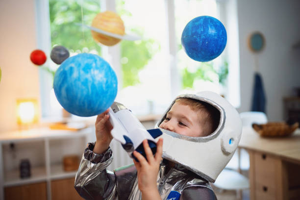 istock Boy in a space suit playing at home, imagining space travel. 2161483986