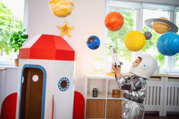 istock Boy in a space suit playing at home, imagining space travel. 2161483998