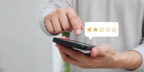 istock close up on customer man use smartphone and hand pressing two star (poor rating) feedback rank for give score point to review the service and experience on business concept 2161484061