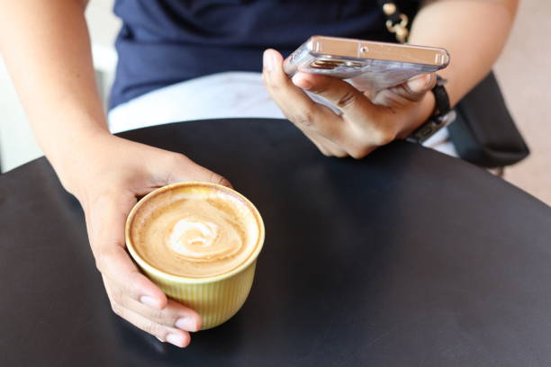istock Woman using smart phone on hand and drink coffee cup 2161484109