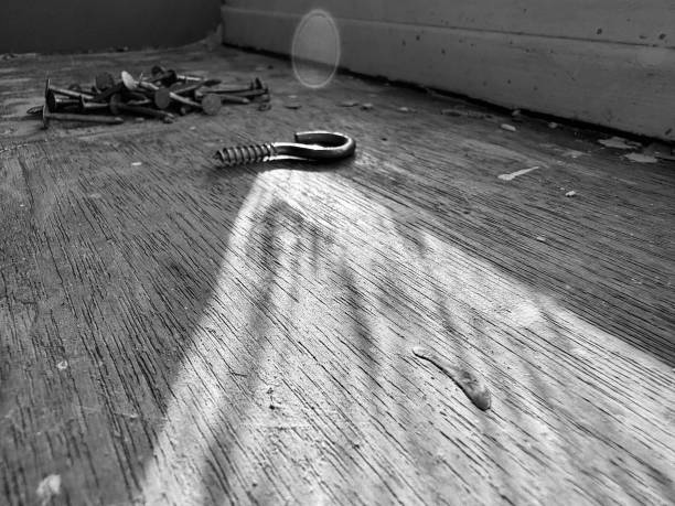 istock Shadows cast across a dirty surface with nails and screws 2161484295