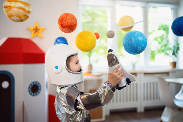 istock Boy in a space suit playing at home, imagining space travel. 2161484470