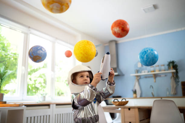 Boy in a space suit playing at home, imagining space travel.