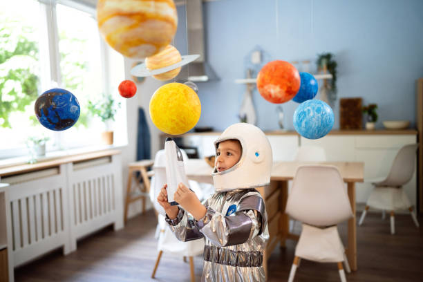 istock Boy in a space suit playing at home, imagining space travel. 2161484552