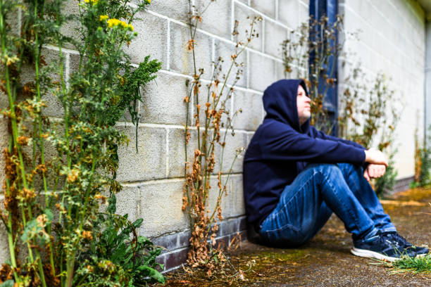 istock Depressed homeless man sitting outside abandoned building 2161486047
