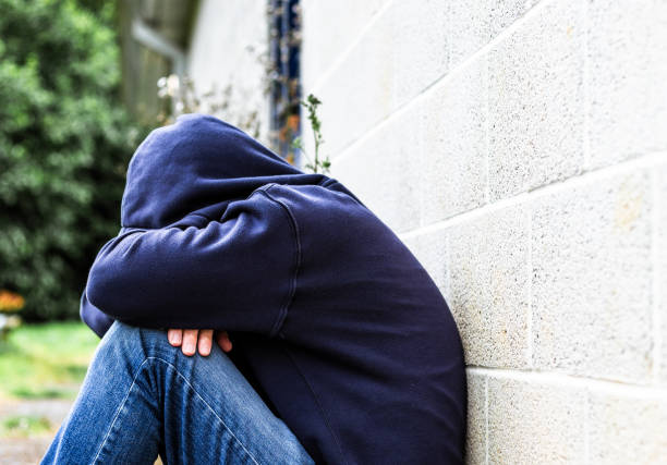 istock Depressed homeless man sitting outside abandoned building 2161486104
