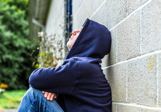 istock Depressed homeless man sitting outside abandoned building 2161486108