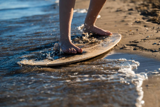 istock Feet Skimboarding on Shallow Beach Waves 2161489231