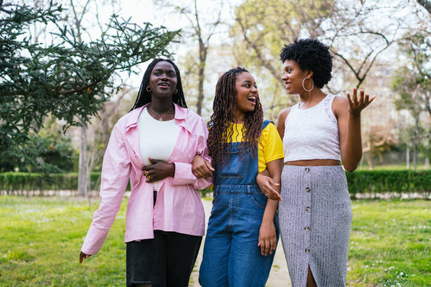 Three women are walking together in a park