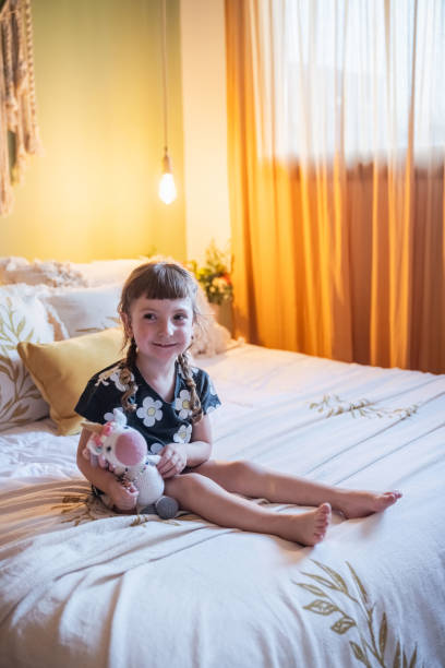 istock Little girl playing on a bed. In a rustic style room. 2161494146