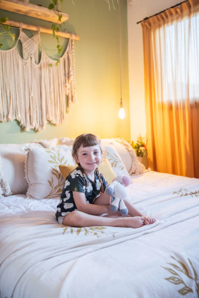 istock Little girl playing on a bed. In a rustic style room. 2161494156