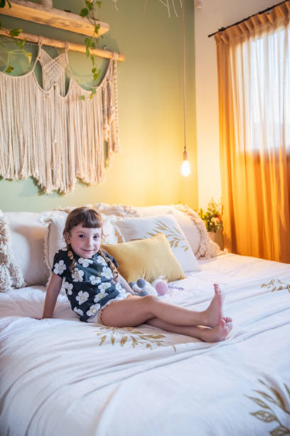 istock Little girl playing on a bed. In a rustic style room. 2161494160