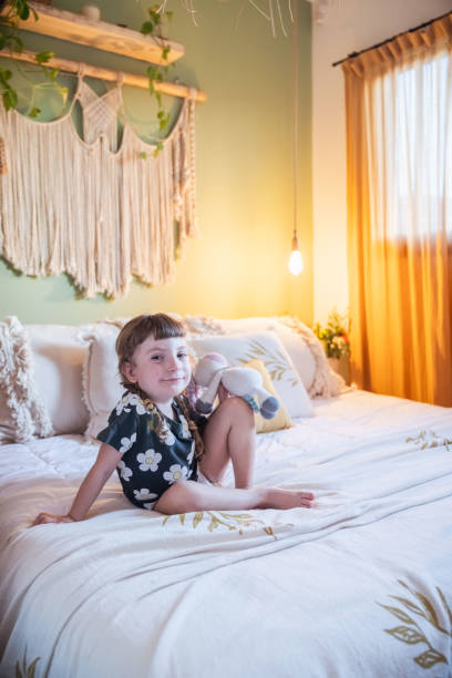 Little girl playing on a bed. In a rustic style room.