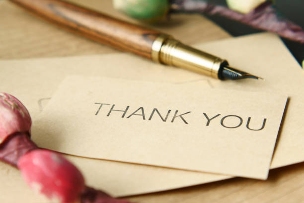 thank you message and envelope on wooden table.