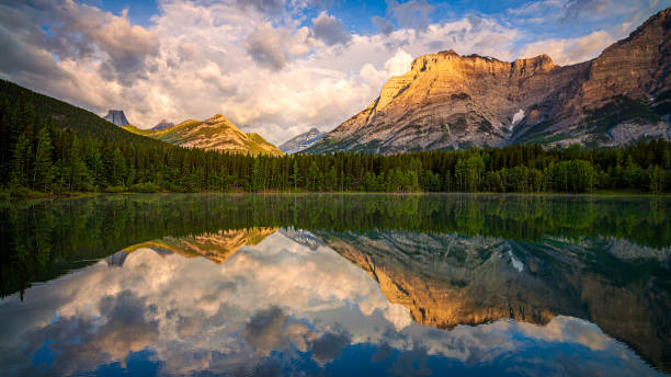 istock Mountains reflecting in calm lake at sunset 2161497780