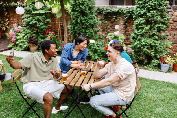 istock Happy friends talking with someone on a video call in the backyard 2161500010