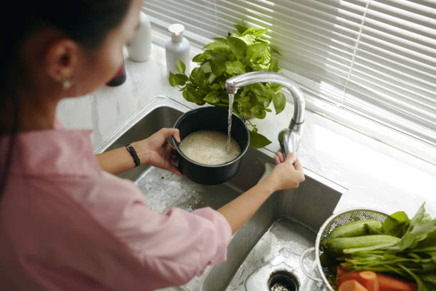 istock Woman Washing Rice In Pan 2161500085