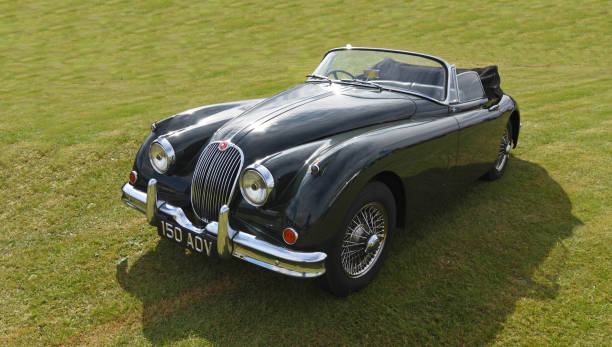Little Gransden, Cambridgeshire, England - August 28, 2022: Classic 1960 Jaguar XK150 drop head coupe parked in field.