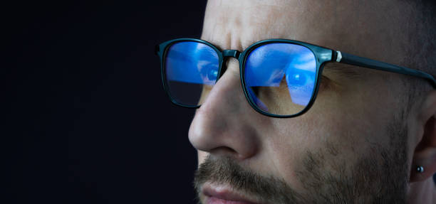 istock Focused eyes of a young man in glasses looking at a computer. Work online, work at the computer until late in the evening, workaholic. Banner. Close-up. Copy space. 2161502115