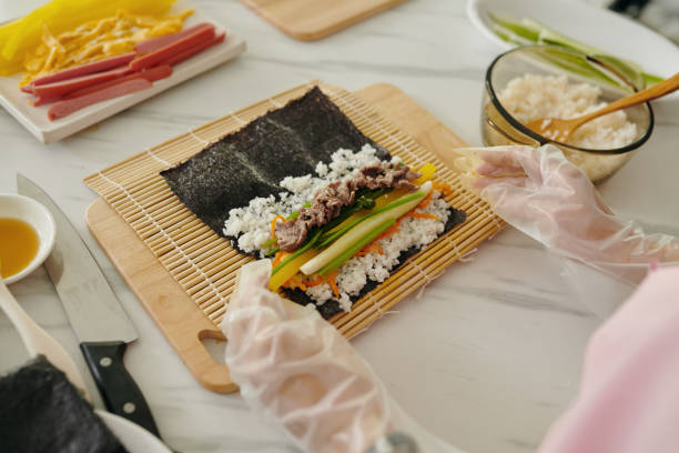 Woman Making Kimbap From Meat And Vegetables