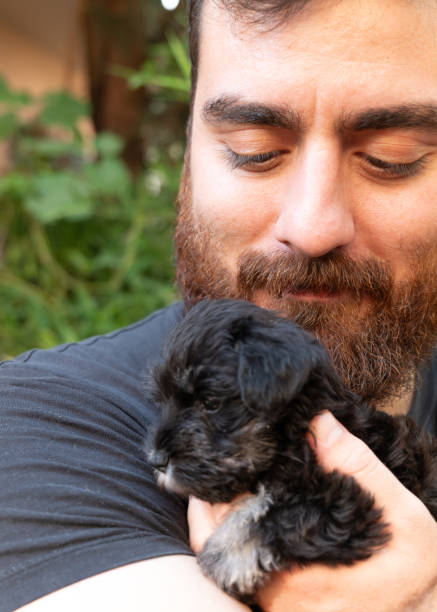 istock Young man hugging her puppy Schnauzer 2161505382