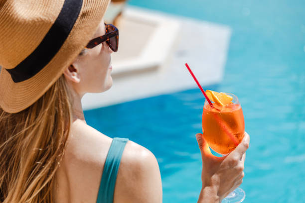 istock Woman enjoying a refreshing drink by the pool 2161505569