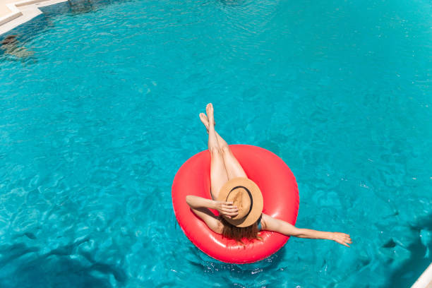 Woman relaxing on inflatable ring in swimming pool